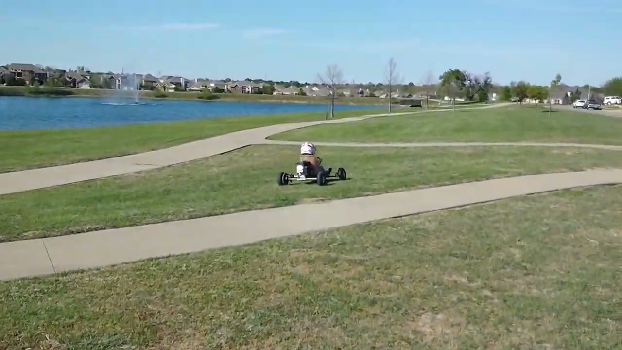 The bare-metal Itzy Bitzy kart on a park path by a lake