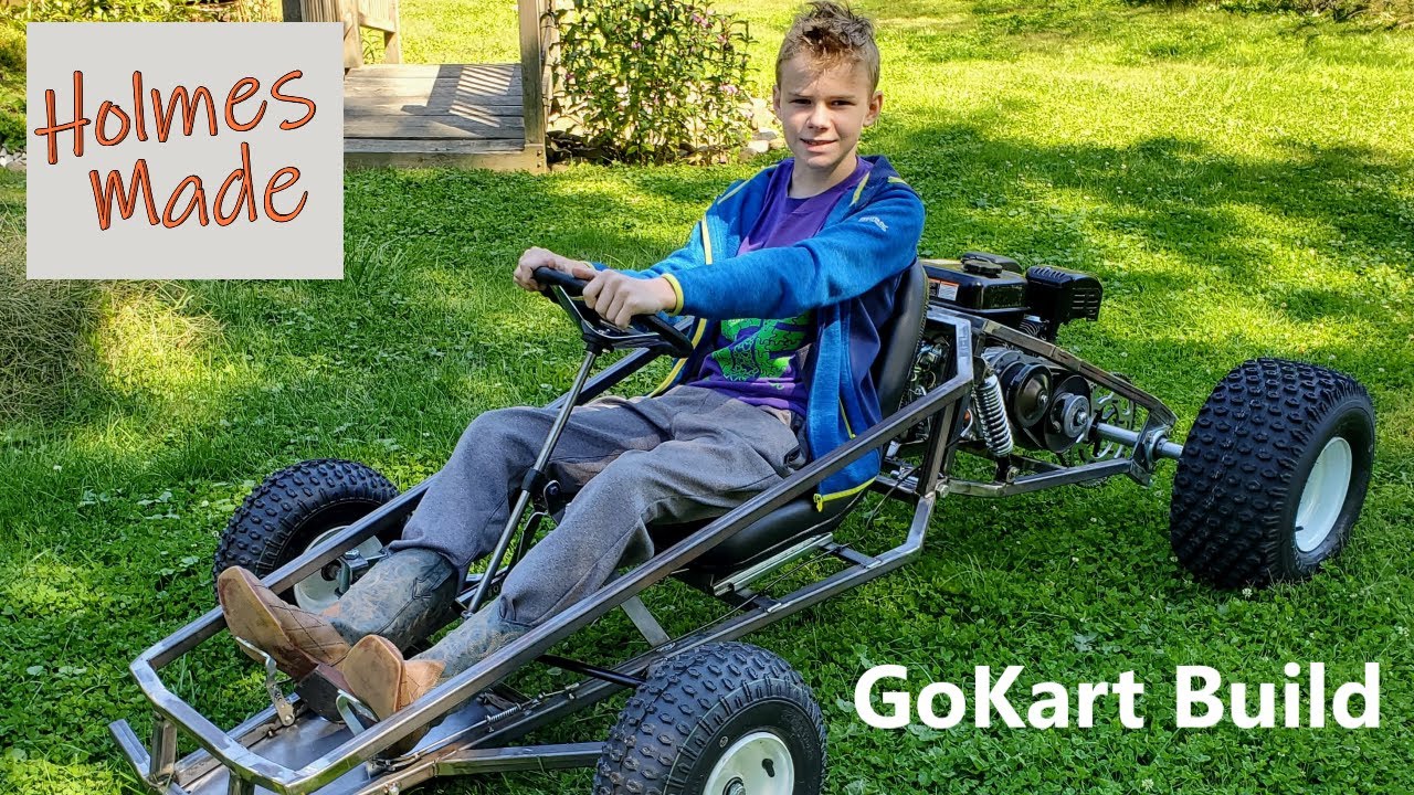 Finished bare-metal SpiderCarts Tarantula go kart with a young driver on grass