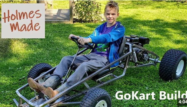 Young builder driving a finished SpiderCarts kart on grass