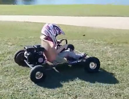 Child in a helmet driving an Itzy Bitzy mini kart