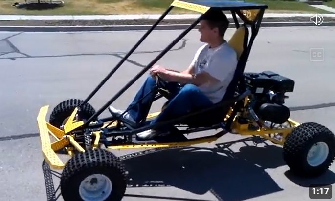 Yellow go kart being driven on pavement